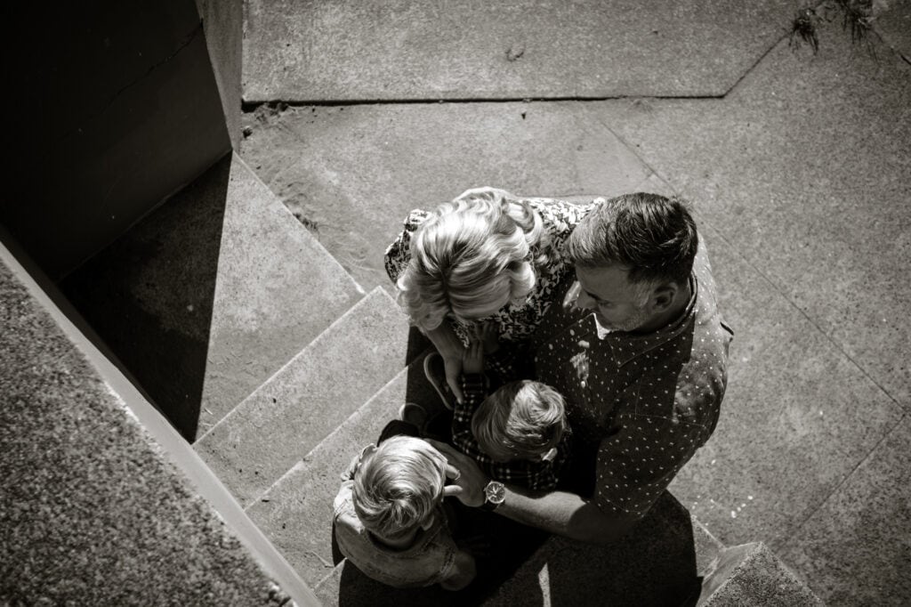 Family embraces while sitting on concrete steps
