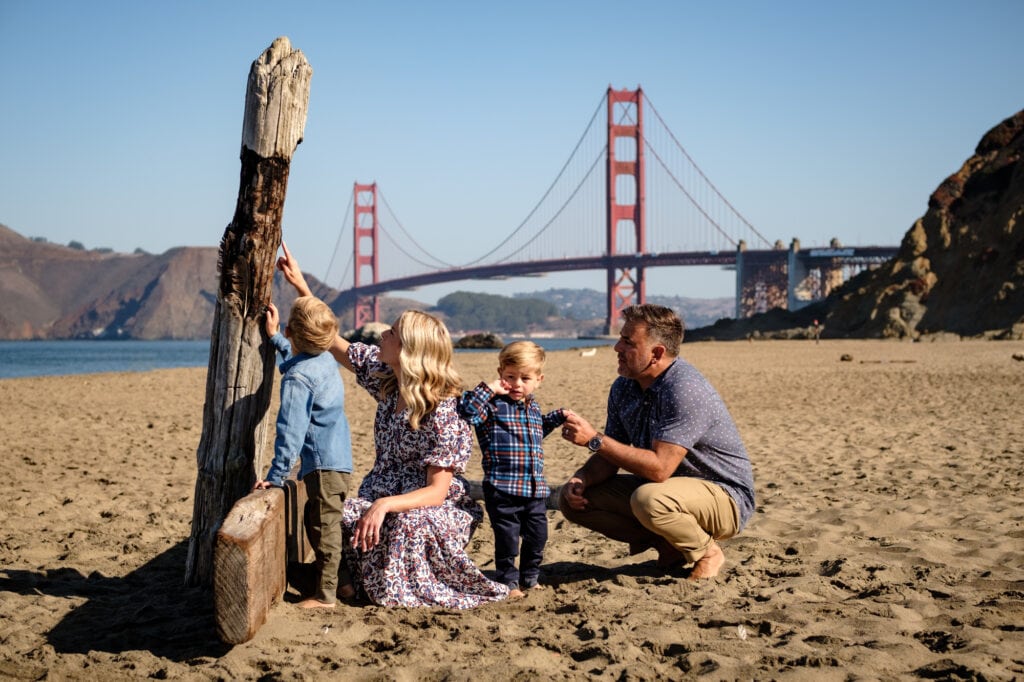 Family of four on a beach in front of the Golden Gate Bridge
