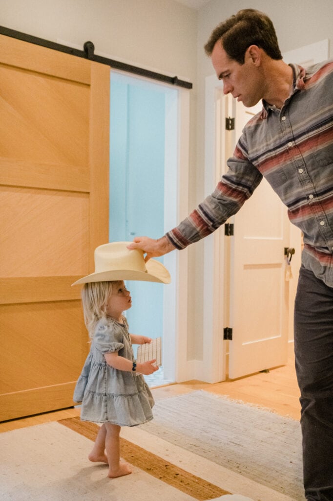 Dad puts cowboy hat on his daughter.