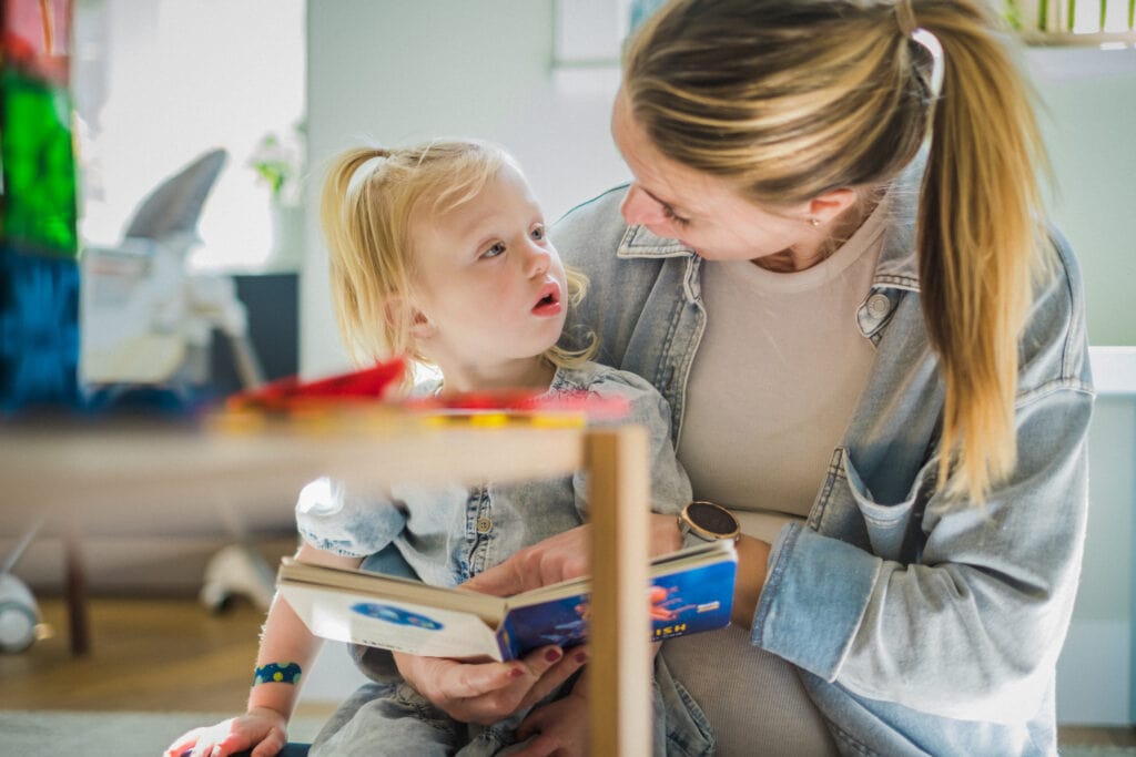 Daughter looks at her mom in wonder during storytime.
