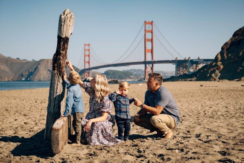 Beach family portrait in front of the Golden Gate Bridge.