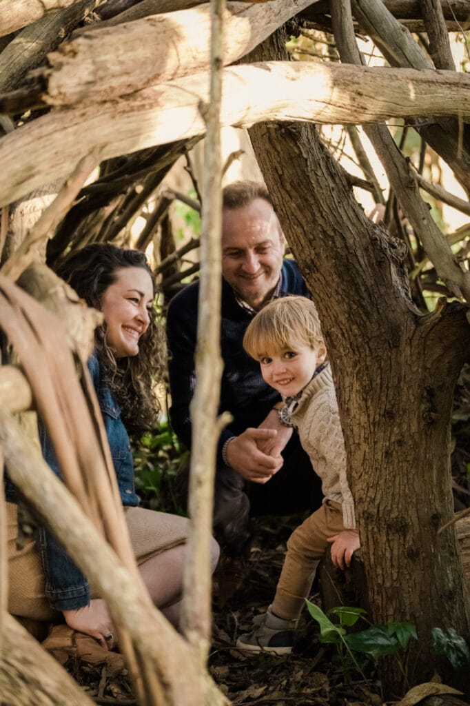 Son and parents in a wooden teepee structure