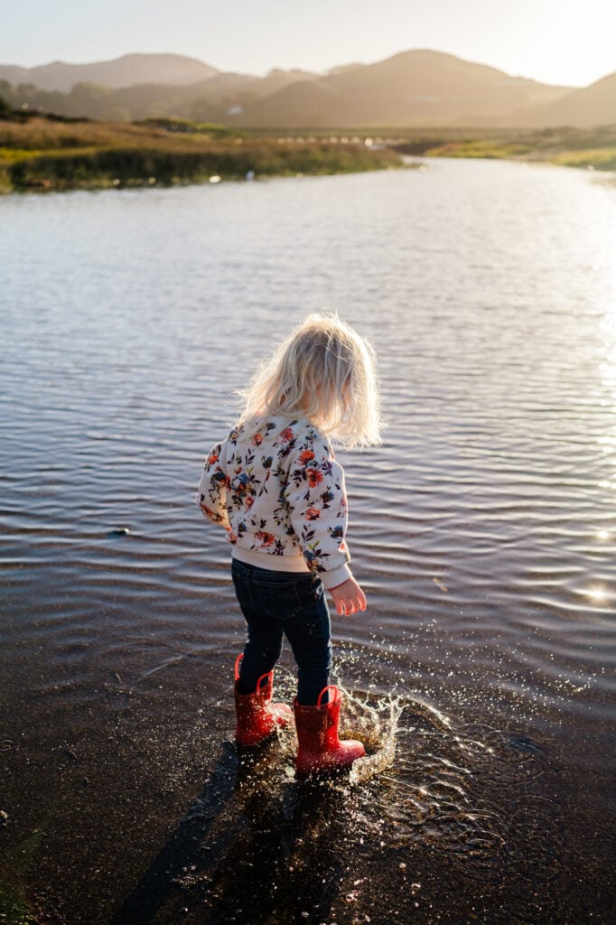 Little girl stomping in a puddle
