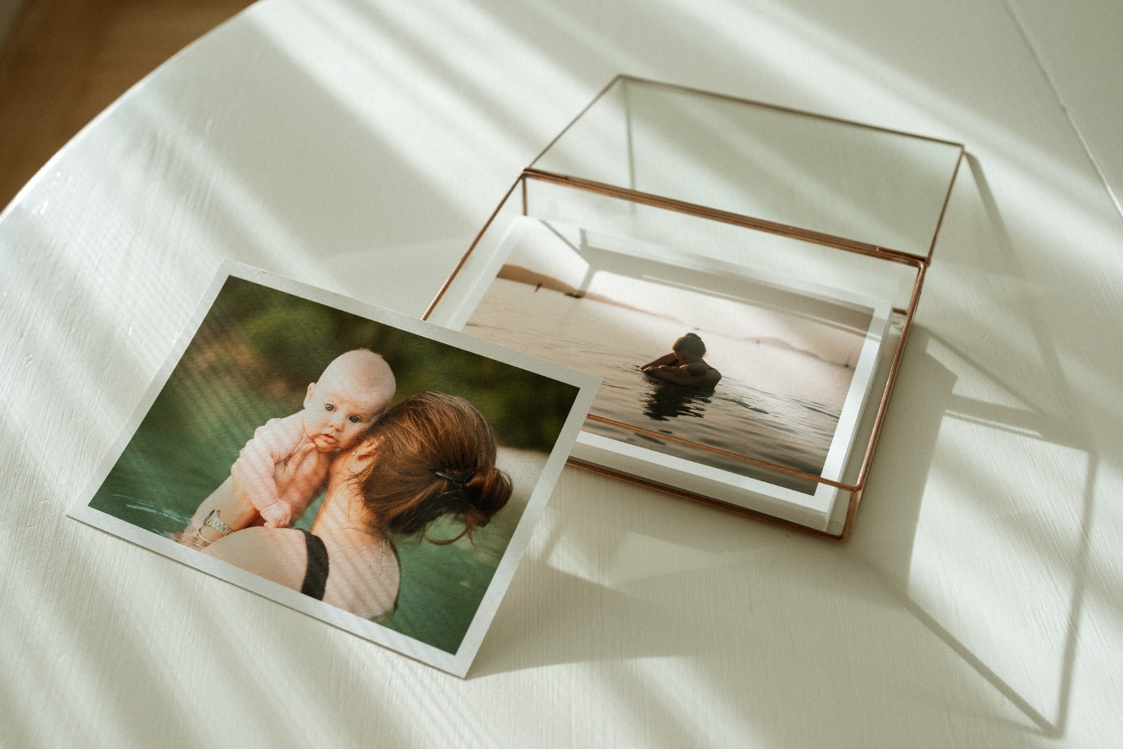 Photo print of mother and baby rests on glass photo box.