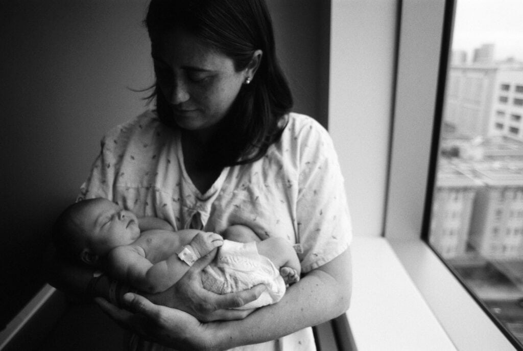 black and white of mom holding newborn in the hospital