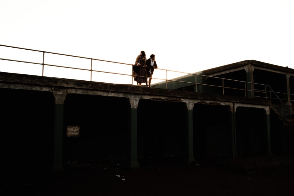Silhouette of couple atop old navy ruins.